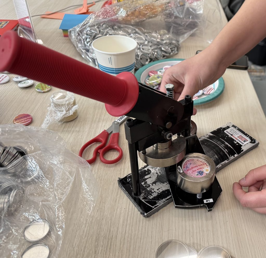 Volunteers make buttons for Discovering Freedom.